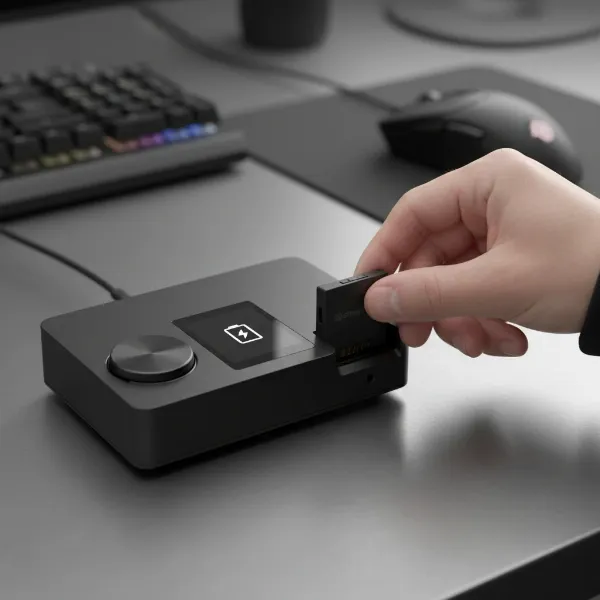 SteelSeries Arctis Nova Pro Wireless GameDAC with a hot-swappable battery being inserted.